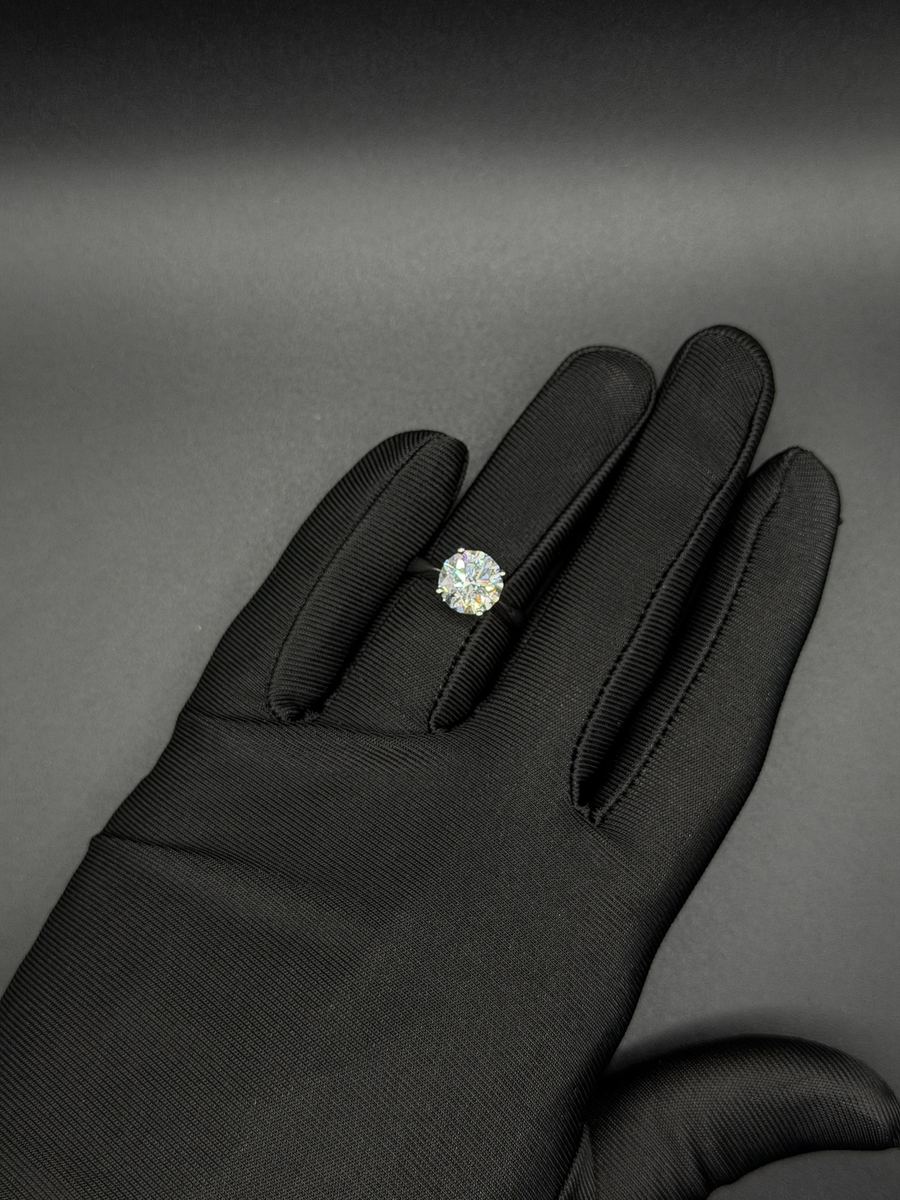 Anello solitario con diamante a taglio brillante su guanto nero
